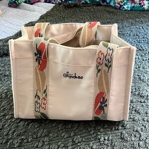 Bag with patterned handles and detachable longer handle